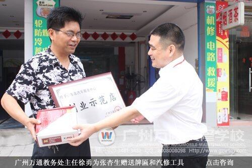 广州万通教务处主任徐勇为张杏生赠送牌匾和汽修工具