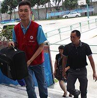 红马甲志愿者为到校来访的学生、家长提行李