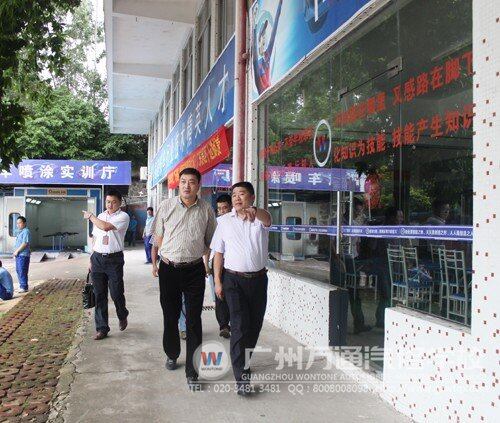 广东省经济技术协作促进会秘书长胡军（左）在我校陈校长（右）的带领下参观学校教学区