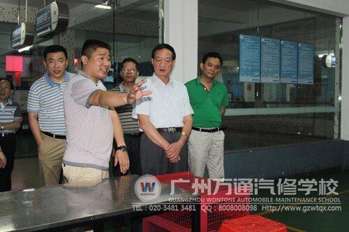 覃局长（前排中）正在参观广州万通汽修学校的实训厅