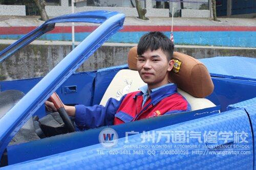 温圣贤坐在自己参与、改装的汽车上，倍感自豪